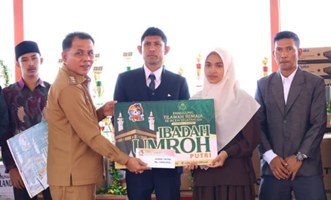 Wakil Bupati Aceh Selatan Baital Mukadis (kiri) didampingi Owner AlifaLand Aidil Mashendra (tengah) menyerahkan hadiah umroh kepada pemenang. Foto: AlifaLand