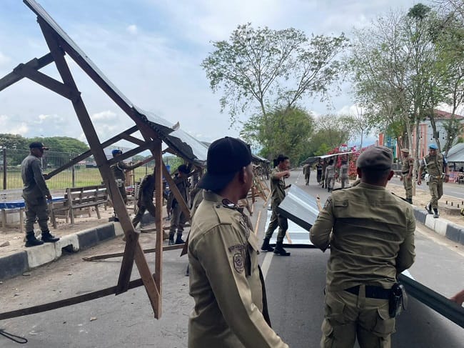 Personel Koramil dan Polsek Blang Bintang, mendampingi petugas Satpol PP dan WH Aceh Besar saat melakukan pembongkaran bangunan pondok pedagang yang berada di trotoar jalan aksen Bandara SIM, Blang Bintang, Aceh Besar, Senin (6/4/2026). FOTO/ MC ACEH BESAR Personel Koramil dan Polsek Blang Bintang, mendampingi petugas Satpol PP dan WH Aceh Besar saat melakukan pembongkaran bangunan pondok pedagang yang berada di trotoar jalan aksen Bandara SIM, Blang Bintang, Aceh Besar, Senin (6/4/2026). FOTO/ MC ACEH BESAR