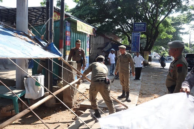 Petugas Satpol PP dan WH Aceh Besar melakukan pembongkaran terhadap bangunan liar di Jalan Laksamana Malahayati, Kecamatan Baitussalam, Kabupaten Aceh Besar, Rabu (22/4/2026). FOTO/ MC ACEH BESAR