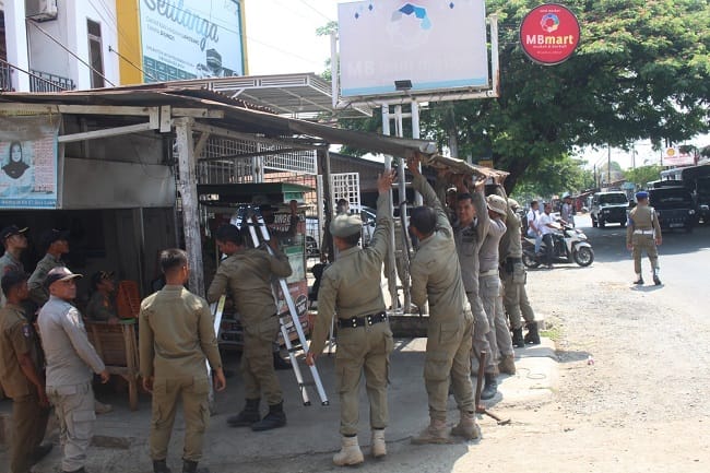 Petugas Satpol PP dan WH Aceh Besar membongkar kanopi yang menjorok ke badan jalan dan fasilitas umum, di kawasan Jalan Laksamana Malahayati, Kecamatan Baitussalam, Kabupaten Aceh Besar, Kamis (23/4/2026). FOTO/ MC ACEH BESAR