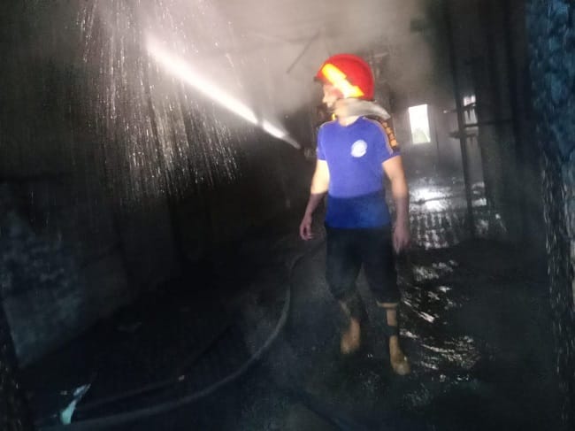 Petugas pemadam kebakaran melakukan pendinginan di lokasi kebakaran toko di kawasan Pasar Lambaro, Kecamatan Ingin Jaya, Aceh Besar, Jumat (1/5/2026). Foto: (Humas BPBD Aceh Besar).