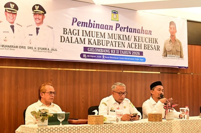 Kadis Pertanahan Aceh Besar Carbaini S.Ag menyampaikan laporannya pada kegiatan Pembinaan Pertanahan bagi Imuem Mukim Gelombang II Tahun 2026 di Ilona Boutique Hotel, Rabu (6/5/2026). FOTO/MC ACEH BESAR