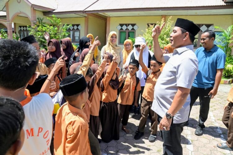Bupati Aceh Besar, Muharram Idris berbincang akrab dengan murid saat berkunjung di SDN Limpok, Darussalam, Aceh Besar, Jumat (8/5/2026). FOTO/MC Aceh Besar