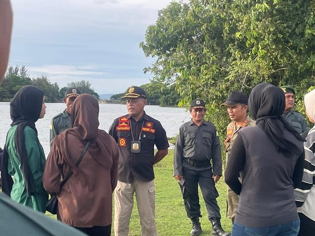 Kasi Penyidik Satpol PP dan WH Aceh Besar Darwadi SAg, memberikan pembinaan kepada pengunjung yang langgar berbusana Islami di kawasan objek wisata Waduk Keliling, Kecamatan Kuta Cot Glie, Kabupaten Aceh Besar, Minggu (17/5/2026) sore. FOTO/ MC ACEH BESAR
