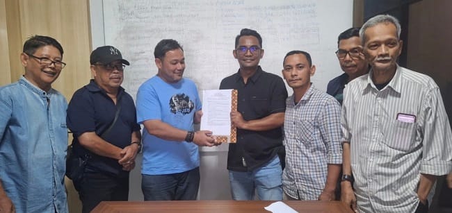 Ketua SC Konferprov XIII PWI Aceh, Azwani Awi menyerahkan dokumen Pakta Integritas SC kepada Ketua OC, M. Nazar Ahadi disaksikan Ketua PWI Aceh, unsur Dewan Penasihat, dan Dewan Kehormatan di Ruang Rapat Kantor PWI Aceh di Banda Aceh, Senin (29/6/2026). (Dok Panitia)