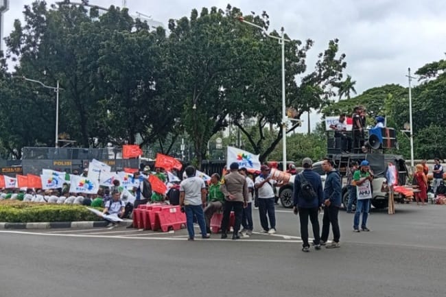 Massa dari Konfederasi Serikat Pekerja Indonesia (KSPI) DKI Jakarta dan KSPI Jawa Barat serta beberapa organisasi buruh lain memulai aksi demonstrasi di sebelah timur kawasan Patung Kuda, Gambir, Jakarta Pusat, Rabu (28/1/2026). Jalan Medan Merdeka Selatan yang mengarah ke Patung Kuda Ditutup karena aksi tersebut.(Kompas.com/Dian Erika)