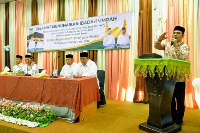 Bupati Aceh Besar, H Muharram Idris memyampaikan sambutan pada acara peusijuk dan pelepasan Jamaah Umrah Para Juara MTQ dan MKQ di Gedung Dekranasda, Gampong Gani, Kecamatan Ingin Jaya, Aceh Besar, Sabtu (27/06/2026). FOTO/MC ACEH BESAR