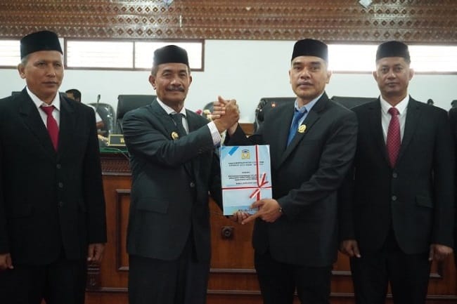 Wakil Bupati Aceh Besar Drs. Syukri A. Jalil menyerahkan dokumen Nota Pengantar Raqan Pertanggungjawaban APBK Tahun Anggaran 2025 pada Rapat Paripurna DPRK Aceh Besar di Kota Jantho, Senin (6/7/2026). FOTO/ MC ACEH BESAR Wakil Bupati Aceh Besar Drs. Syukri A. Jalil menyerahkan dokumen Nota Pengantar Raqan Pertanggungjawaban APBK Tahun Anggaran 2025 pada Rapat Paripurna DPRK Aceh Besar di Kota Jantho, Senin (6/7/2026). FOTO/ MC ACEH BESAR