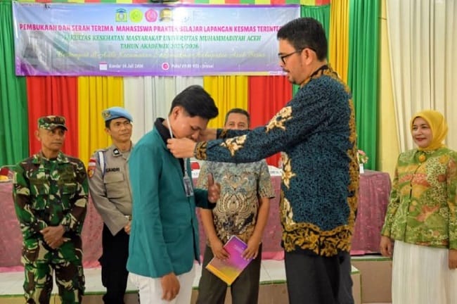Staf Ahli Bupati Aceh Besar, Fata Muhammad SPd MM menyematkan tanda peserta PBL Kesmas Terintegrasi di Aula Kantor Camat Sukamakmur, Aceh Besar, Kamis (16/07/2026). FOTO/MC ACEH BESAR