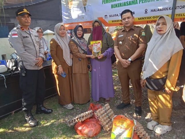 Camat Darul Kamal, Husaini, S.Pd.I., menyerahkan secara simbolis bahan pangan yang di beli masyarakat pada pelaksanaan Gerakan Pangan Murah (GPM) yang berlangsung di halaman Kantor Camat Darul Kamal, Kabupaten Aceh Besar, Selasa (7/7/2026) FOTO/MC AC Camat Darul Kamal, Husaini, S.Pd.I., menyerahkan secara simbolis bahan pangan yang di beli masyarakat pada pelaksanaan Gerakan Pangan Murah (GPM) yang berlangsung di halaman Kantor Camat Darul Kamal, Kabupaten Aceh Besar, Selasa (7/7/2026) FOTO/MC AC