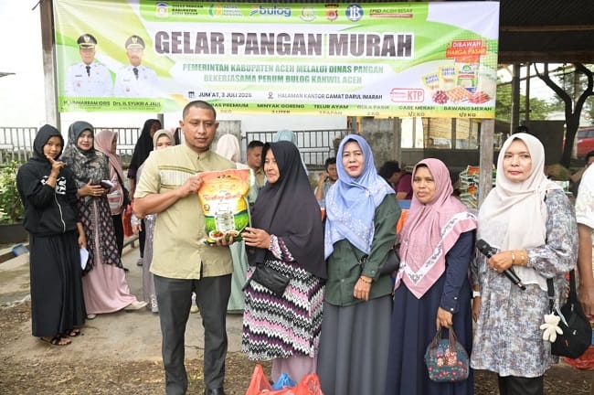 Kabid Distribusi dan Cadangan Pangan, Idarlaila, SP MP menyerahkan secara simbolis paket belanja pada pangan murah yang digelar oleh Pemkab Aceh Besar melalui Dinas Pangan di Halaman Kantor Camat Darul Imarah, Aceh Besar, Jumat (03/07/2026). FOTO/MC ACEH BESAR Kabid Distribusi dan Cadangan Pangan, Idarlaila, SP MP menyerahkan secara simbolis paket belanja pada pangan murah yang digelar oleh Pemkab Aceh Besar melalui Dinas Pangan di Halaman Kantor Camat Darul Imarah, Aceh Besar, Jumat (03/07/2026). FOTO/MC ACEH BESAR