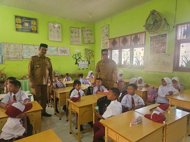 Kasatpol PP dan WH Aceh Besar Muhajir SSTP MPA, dan Camat Kuta Baro Zahrul Fuadi SE MM, berdialog dengan para orang tua peserta didik baru di SDN Leupung 26 Kabupaten Aceh Besar, Senin (13/7/2026). FOTO/ MC ACEH BESAR