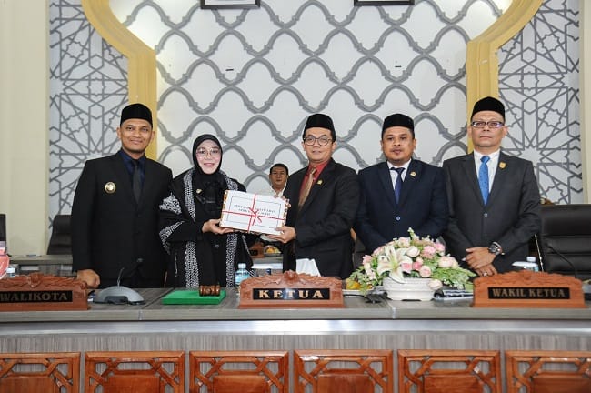 Foto: Humas DPRK Banda Aceh Wali Kota Banda Aceh, Illiza Sa’aduddin Djamal, saat menyerahkan Laporan Keterangan Pertanggungjawaban (LKPJ) Tahun Anggaran 2025 kepada DPRK Banda Aceh kepada Ketua DPRK Banda Aceh, Irwansyah ST, didampingi Wakil Ketua I Daniel Abdul Wahab, S.Pd., dan Wakil Ketua II, Dr. Musriadi Aswad, S.Pd., M.Pd dalam rapat paripurna di Gedung DPRK Banda Aceh, Senin (13/7/2026). Foto: Humas DPRK Banda Aceh Wali Kota Banda Aceh, Illiza Sa’aduddin Djamal, saat menyerahkan Laporan Keterangan Pertanggungjawaban (LKPJ) Tahun Anggaran 2025 kepada DPRK Banda Aceh kepada Ketua DPRK Banda Aceh, Irwansyah ST, didampingi Wakil Ketua I Daniel Abdul Wahab, S.Pd., dan Wakil Ketua II, Dr. Musriadi Aswad, S.Pd., M.Pd dalam rapat paripurna di Gedung DPRK Banda Aceh, Senin (13/7/2026).