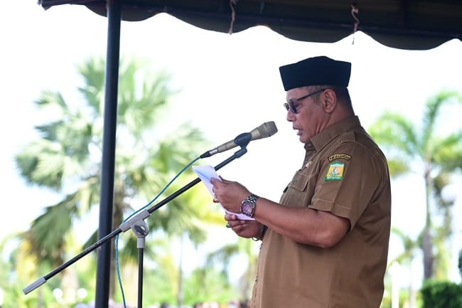 Sekda Aceh Besar Bahrul Jamil saat membacakan amanat Menteri Pemberdayaan Perempuan dan Perlindungan Anak Republik Indonesia, sebagai Inspektur Upacara Peringatan Hari Anak Nasional ke 42 & HARGANAS KE-33, di Halaman Kantor Bupati, Kota Jantho, Senin (27/07/2026). FOTO/MC ACEH BESAR