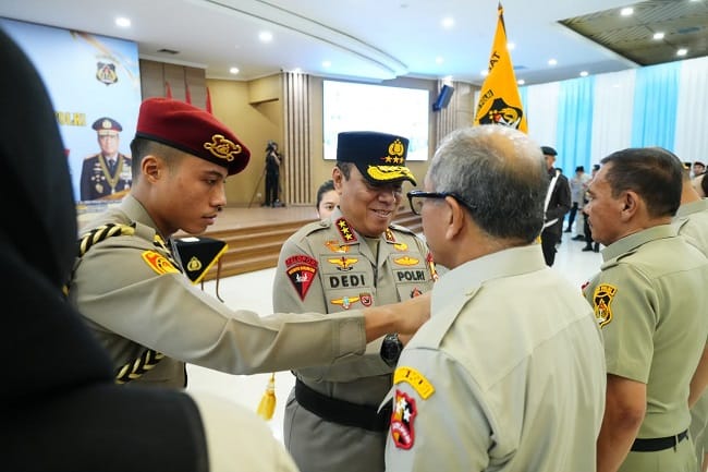 Foto: Kapolda Aceh Irjen Pol. Dedi menyematkan tanda penghormatan kepada personel purnawirawan pada acara Purna Bhakti Polri di Polda Aceh, Rabu (29/7/2026).