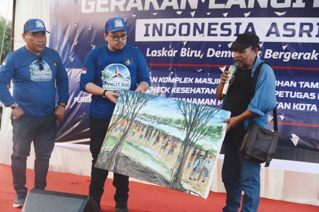 Pelukis Aceh, Salaudin, menyerahkan sebuah lukisan kepada Pelaksana Tugas (Plt) Ketua DPD Partai Demokrat Aceh, Rian Syaf, pada peringatan HUT ke-25 Partai Demokrat yang dirangkai dengan kegiatan Gerakan Langit Biru Indonesia Asri, di kawasan Pantai Tibang, Banda Aceh, Jumat, 31 Juli 2026. Foto: Dok. Partai Demorat Aceh Pelukis Aceh, Salaudin, menyerahkan sebuah lukisan kepada Pelaksana Tugas (Plt) Ketua DPD Partai Demokrat Aceh, Rian Syaf, pada peringatan HUT ke-25 Partai Demokrat yang dirangkai dengan kegiatan Gerakan Langit Biru Indonesia Asri, di kawasan Pantai Tibang, Banda Aceh, Jumat, 31 Juli 2026. Foto: Dok. Partai Demorat Aceh