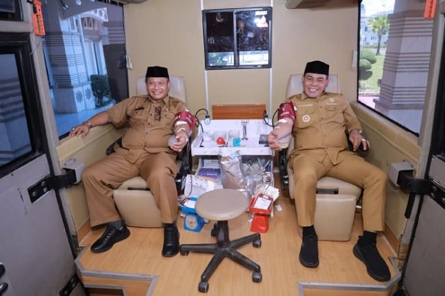 Bupati Aceh Besar H Muharram Idris, Sekda Bahrul Jamil SSos MSi mendonorkan darahnya pada kegiatan donor darah yang digelar di Kantor Bupati Aceh Besar, Senin (27/7/2026). FOTO/ PROKOPIM PEMKAB ACEH BESAR