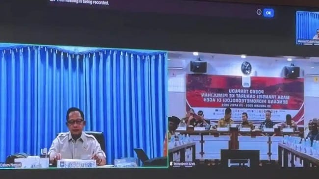 RAPAT LEWAT ZOOM – Mendagri Muhammad Tito Karnavian, mengikuti secara virtual Zoom Rapat Koordinasi Pengakhiran Masa Transisi Darurat Menuju Rehabilitasi dan Rekonstruksi Pascabencana Hidrometeorologi yang digelar di Kantor Gubernur Aceh, Selasa (28/7/2026).
