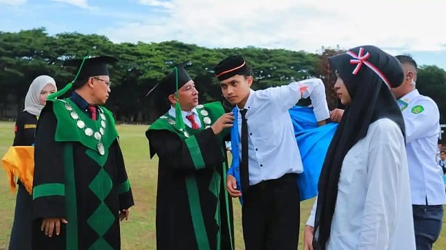 MEMAKAIKAN ALMAMATER – Plh Rektor Prof Dr Khairuddin memakaikan almamater secara simbolis kepada salah seorang mahasiswa baru pada pembukaan PBAK Tahun Akademik 2026/2027 di Lapangan Bola UIN Ar-Raniry Banda Aceh, Senin (24/8/2026). MEMAKAIKAN ALMAMATER – Plh Rektor Prof Dr Khairuddin memakaikan almamater secara simbolis kepada salah seorang mahasiswa baru pada pembukaan PBAK Tahun Akademik 2026/2027 di Lapangan Bola UIN Ar-Raniry Banda Aceh, Senin (24/8/2026).