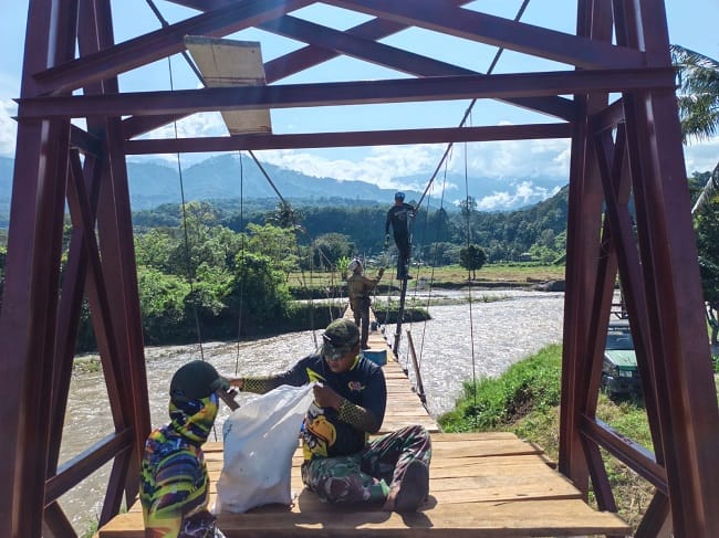 Babinsa Kodim 0108/Aceh Tenggara bersama warga bergotong royong memasang papan lantai Jembatan Gantung Perintis di Desa Kuta Ujung, Kecamatan Darul Hasanah, Senin (3/8/2026). Jembatan ini akan menjadi akses vital bagi masyarakat menuju kawasan perkebunan sekaligus memperkuat konektivitas wilayah. Babinsa Kodim 0108/Aceh Tenggara bersama warga bergotong royong memasang papan lantai Jembatan Gantung Perintis di Desa Kuta Ujung, Kecamatan Darul Hasanah, Senin (3/8/2026). Jembatan ini akan menjadi akses vital bagi masyarakat menuju kawasan perkebunan sekaligus memperkuat konektivitas wilayah.