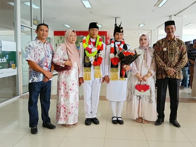 Foto bersama pada penyambutan kepulangan Muhammad Hibban Annafis, di Bandara SIM, Blang Bintang, Aceh Besa, Sabtu (22/8/2026). FOTO/ MC ACEH BESAR