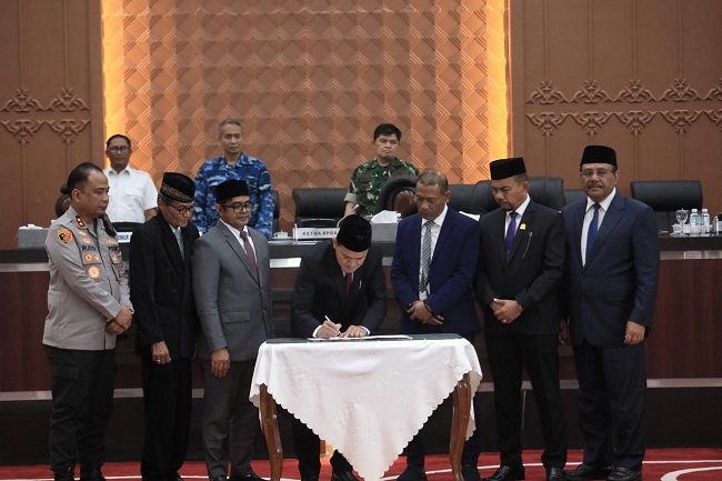 Wakil Gubernur Aceh, H. Fadhlullah, didampingi Plt. Sekda Aceh, Taufik, ST, M.Si, saat menandatangani dokumen persetujuan Raqan Aceh tentang Pertanggungjawaban APBA Anggaran 2025 bersama Pimpinan DPRA dalam Rapat Paripurna di Gedung Utama DPRA, Banda Aceh, Kamis (27/8/2026).
