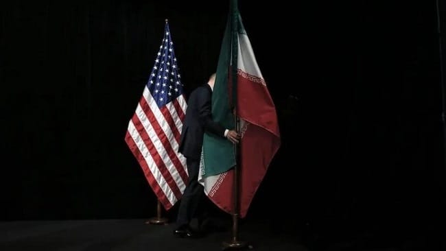 Ilustrasi bendera Iran dan Amerika Serikat (Foto: dok. CARLOS BARRIA/POOL/AFP via Getty Images)