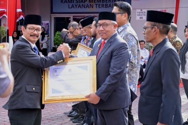 Asisten 1 Sekdakab Aceh Besar, Fahan AP menerima Piagam Penghargaan Mitra Kerja dari Kakanwil Kemenkumham Aceh, Dr. Drs. Meurah Budiman, S.H., M.H pada Upacara dan Syukuran Peringatan Hari Pengayoman ke 81 di Kantor Kemenkumham Aceh, Banda Aceh,
