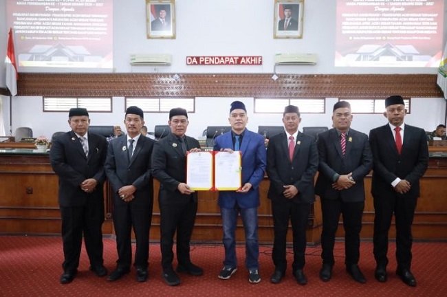 Bupati Aceh Besar H Muharram Idris (Syech Muharram), menyerahkan Raqan Perubahan APBK 2026 kepada Ketua DPRK Aceh Besar Abdul Muchti SIKom, pada Rapat Paripurna IX, di Aula Rapat DPRK Aceh Besar, Kota Jantho, Senin (28/9/2026). FOTO/ PROKOPIM PEMKAB