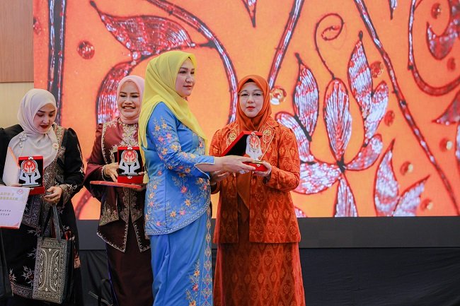 Ketua Dekranasda Aceh Besar, Hj Rita Mayasari, menerima plakat Juara I Galeri Terbaik Dekranasda Kabupaten/Kota se-Aceh, dari Ketua Dekranasda Aceh, Marlina Usman, dalam Rakerda Dekranasda Aceh di Galeri Dekranasda Aceh, Taman Sulthanah Safiatuddin, Banda Aceh, Minggu (12/9/2026). FOTO/ MC ACEH BESAR