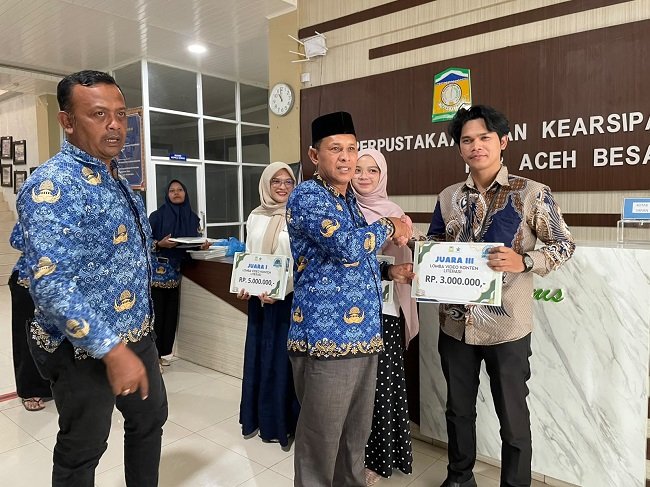 Kepala Dinas Perpustakaan dan Kearsipan Aceh Besar, Fazlun SH MT menyerahkan hadiah kepada para pemenang Lomba Film Konten Literasi di Kota Jantho, Aceh Besar, Kamis (17/9/2026). FOTO/ MC ACEH BESAR Kepala Dinas Perpustakaan dan Kearsipan Aceh Besar, Fazlun SH MT menyerahkan hadiah kepada para pemenang Lomba Film Konten Literasi di Kota Jantho, Aceh Besar, Kamis (17/9/2026). FOTO/ MC ACEH BESAR