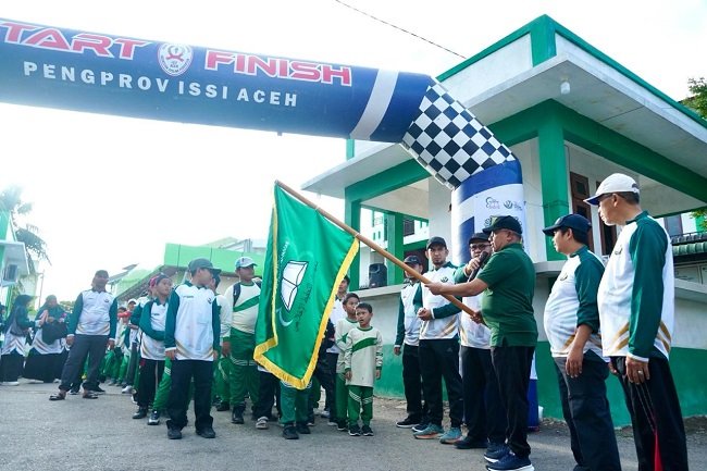 Asisten I Sekdakab Aceh Besar Farhan AP melepas peserta jalan santai Milad ke-17 Ma’had Daarut Tahfizh Al Ikhlas di Komplek Vila Buana, Darul Imarah, Minggu (27/9/2026). FOTO/ MC ACEH BESAR
