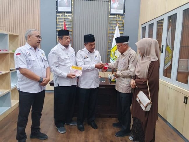Wakil Bupati Aceh Besar Drs Syukri menyerahkan cenderamata dari Pemerintah Aceh kepada ahli waris keluarga pahlawan T Nyak Makam di ruang kerja Wabup Aceh Besar, Rabu (16/9/2026). FOTO/ PROKOPIM PEMKAB ACEH BESAR
