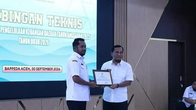 Bupati Aceh Besar H Muharram Idris yang diwakili Kepala Bappeda Aceh Besar Agus Husni SP menerima penghargaan bergengsi sebagai Pemerintah Daerah Pengelola Keuangan Berpredikat “Baik” dengan Skor 80,379 “Kategori Kapasitas Fiskal Rendah” berdasarkan hasil pengukuran Indeks Pengelolaan Keuangan Daerah Tahun Anggaran 2024 tahun ukur 2025 di Aula Bappeda Aceh, Rabu (30/9/2026). FOTO/ DOK BAPPEDA ACEH BESAR Bupati Aceh Besar H Muharram Idris yang diwakili Kepala Bappeda Aceh Besar Agus Husni SP menerima penghargaan bergengsi sebagai Pemerintah Daerah Pengelola Keuangan Berpredikat “Baik” dengan Skor 80,379 “Kategori Kapasitas Fiskal Rendah” berdasarkan hasil pengukuran Indeks Pengelolaan Keuangan Daerah Tahun Anggaran 2024 tahun ukur 2025 di Aula Bappeda Aceh, Rabu (30/9/2026). FOTO/ DOK BAPPEDA ACEH BESAR