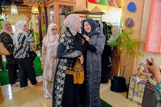 Ketua Dekranasda Aceh Besar, Hj Rita Mayasari mengalungkan sal kepada Ketua IADbDaerah Aceh Besar, Ny. Isyana Wisnu saat tiba di Gedung Dekranasda, Gampong Gani, Kecamatan Ingin Jaya, Aceh Besar, Selasa (06/10/2026). FOTO/MC ACEH BESAR