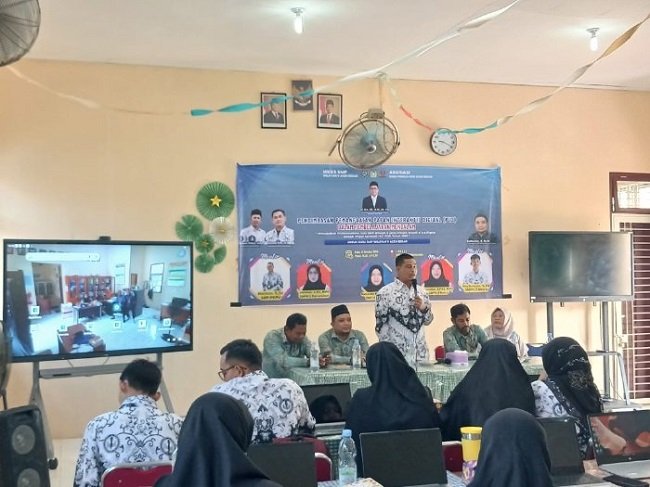 Sekretaris PGRI Aceh Besar, Fakhriadi SPd MSi, memberikan sambutan fan sekaligus membuka pelatihan pengimbasan pemanfaatan PID dalam pembelajaran mendalam di SMP Negeri 1 Darussalam, Kecamatan Darussalam, Aceh Besar, Rabu (14/10/2026). FOTO/ MC ACEH