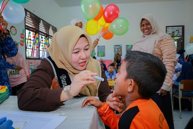 Bunda PAUD Kabupaten Aceh Besar, Hj Rita Mayasari turut mengecek kesehatan murid PAUD, di PAUD Negeri Leupung, Gampong Meunasah Mesjid, Kecamatan Leupung, Aceh Besar, Kamis (1/10/2026). FOTO/ MC ACEH BESAR