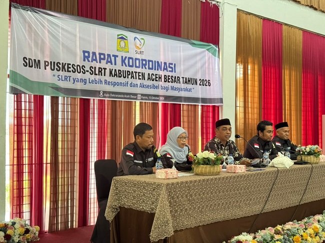 Kadis Sosial Aceh Besar Darwan Asrizal SE MT memberikan sambutan pada rapat koordinasi pengelola Pusat Kesejahteraan Sosial (Puskesos) dan Sistem Layanan dan Rujukan Terpadu (SLRT) Tahun 2026, di Aula Dekranasda Aceh Besar, Kecamatan Ingin Jaya, Kabupaten Aceh Besar, Kamis (15/10/2026). FOTO/ MC ACEH BESAR Kadis Sosial Aceh Besar Darwan Asrizal SE MT memberikan sambutan pada rapat koordinasi pengelola Pusat Kesejahteraan Sosial (Puskesos) dan Sistem Layanan dan Rujukan Terpadu (SLRT) Tahun 2026, di Aula Dekranasda Aceh Besar, Kecamatan Ingin Jaya, Kabupaten Aceh Besar, Kamis (15/10/2026). FOTO/ MC ACEH BESAR