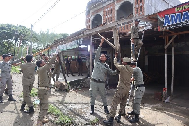 Petugas Satpol PP dan WH Aceh Besar membongkar kanopi yang langgar aturan, di kawasan pintu masuk Bandara SIM, Kecamatan Blang Bintang, Aceh Besar, Rabu (21/10/2026). FOTO/ DOK MC ACEH BESAR Petugas Satpol PP dan WH Aceh Besar membongkar kanopi yang langgar aturan, di kawasan pintu masuk Bandara SIM, Kecamatan Blang Bintang, Aceh Besar, Rabu (21/10/2026). FOTO/ DOK MC ACEH BESAR
