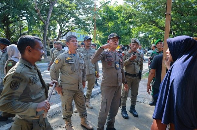 Kepala Bidang Ketertiban Umum dan Ketenteraman Masyarakat, Suhaimi SP, berdialog dengan pemilik bangunan, di jalan lintas Bandara SIM, Kecamatan Blang Bintang, Aceh Besar, Rabu (14/10/2026). FOTO/ MC ACEH BESAR