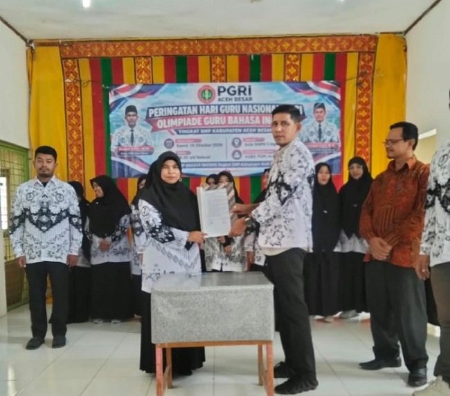 Ketua PGRI Aceh Besar, Munadi, S.Pd.I., M.Pd., menyerahkan berita acara pelantikan pengurus Asosiasi Guru Bahasa Asing masa bakti 2025–2030, di Aula SMPN 3 Ingin Jaya, Aceh Besar, Kamis (15/10/2026). FOTO/ MC ACEH BESAR Ketua PGRI Aceh Besar, Munadi, S.Pd.I., M.Pd., menyerahkan berita acara pelantikan pengurus Asosiasi Guru Bahasa Asing masa bakti 2025–2030, di Aula SMPN 3 Ingin Jaya, Aceh Besar, Kamis (15/10/2026). FOTO/ MC ACEH BESAR